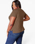 A woman modeling a short-sleeve brown t-shirt from the back, paired with blue jeans, against a plain white background.