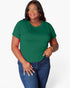 A woman modeling a short-sleeve crewneck t-shirt in forest green, paired with blue jeans, against a plain light gray background.