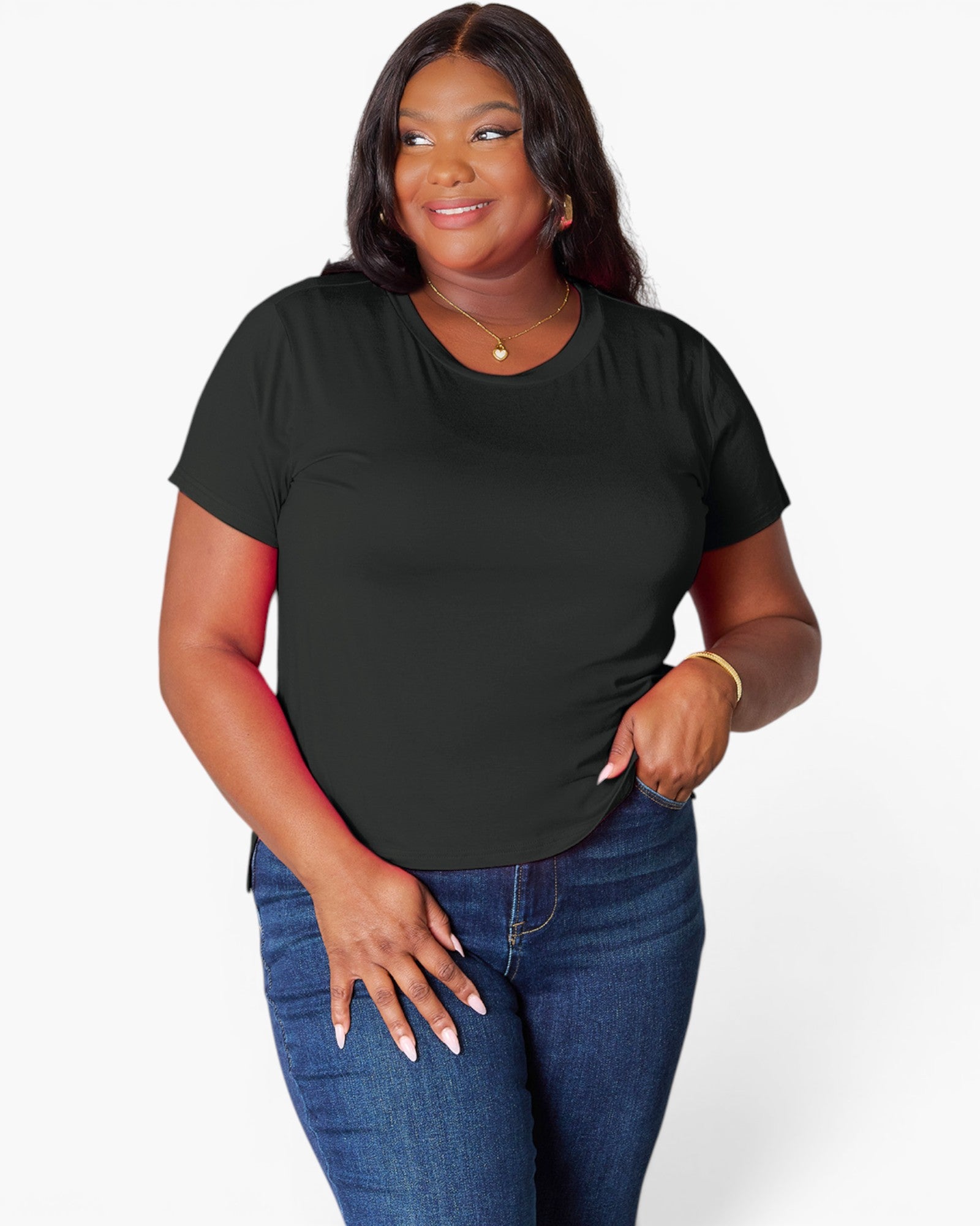A woman modeling a black short-sleeve crewneck t-shirt paired with blue jeans, standing against a light gray studio background.