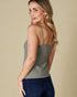 Woman wearing a green tank top against a beige background