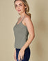 Woman wearing a green tank top against a beige background