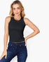 A woman modeling a sleeveless black crop top paired with dark blue jeans, photographed against a clean white studio background.