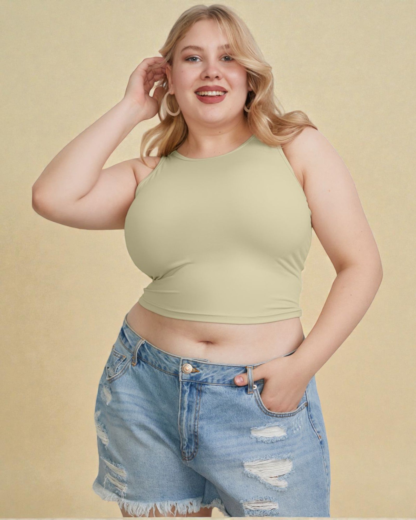 Woman wearing a green crop top and denim shorts on a beige background