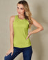Woman wearing a green sleeveless top and blue jeans against a beige background