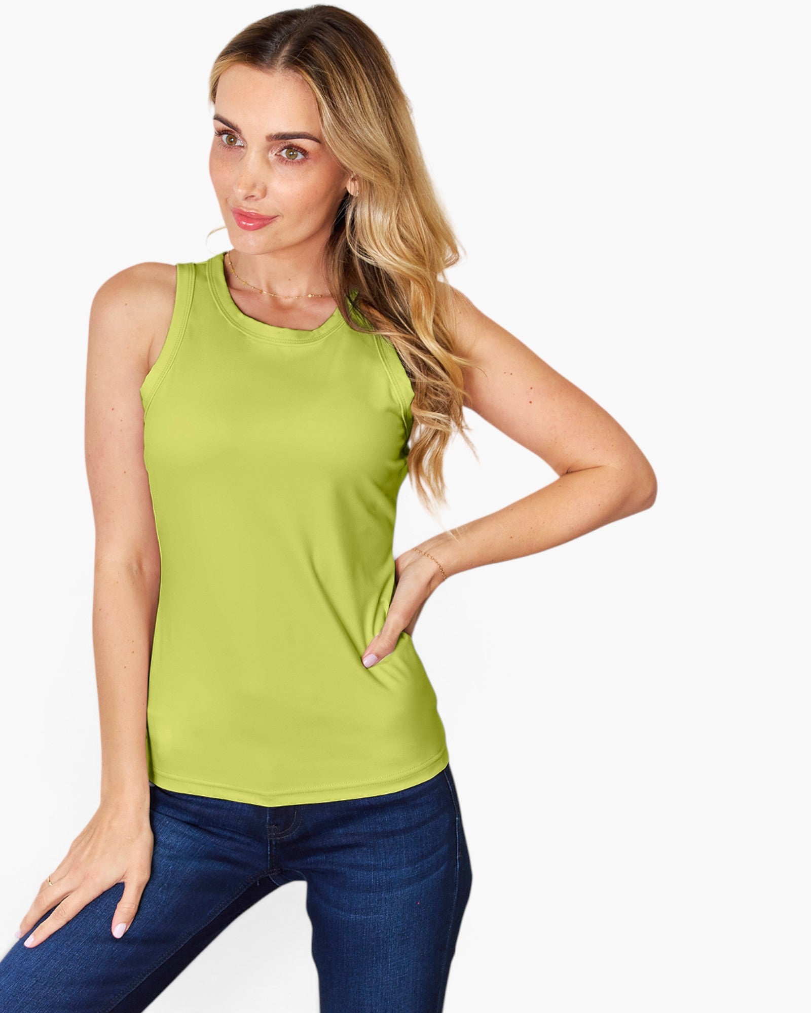 A woman modeling a sleeveless lime green tank top paired with dark blue jeans, set against a plain light gray background.