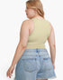 A woman shown from the back wearing a light sage green ribbed tank top and light blue denim shorts against a plain white background.