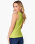 A woman wearing a bright lime green sleeveless tank top and blue jeans, shown from a three-quarters back view against a light gray studio background.