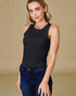 Woman wearing a black sleeveless top and blue jeans against a beige background