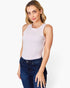 A woman modeling a sleeveless light pink tank top paired with dark blue jeans, photographed against a clean white studio background.