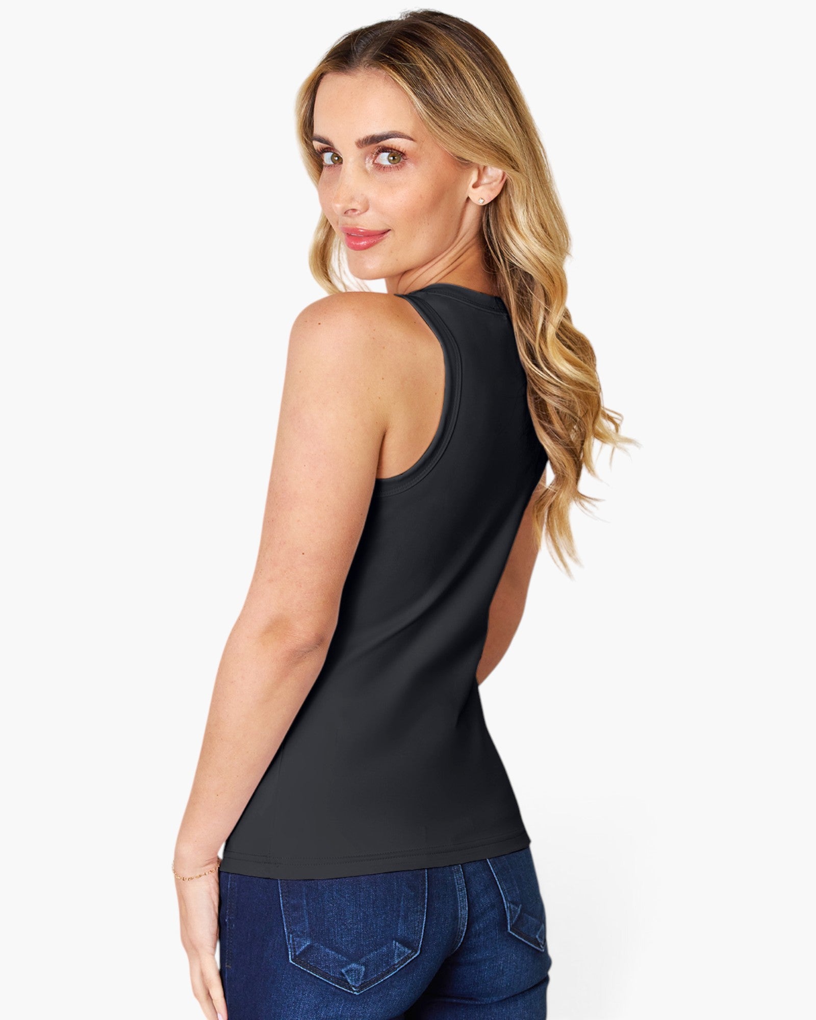 A woman wearing a black sleeveless tank top and blue jeans, shown from a side-back angle against a light gray studio background.