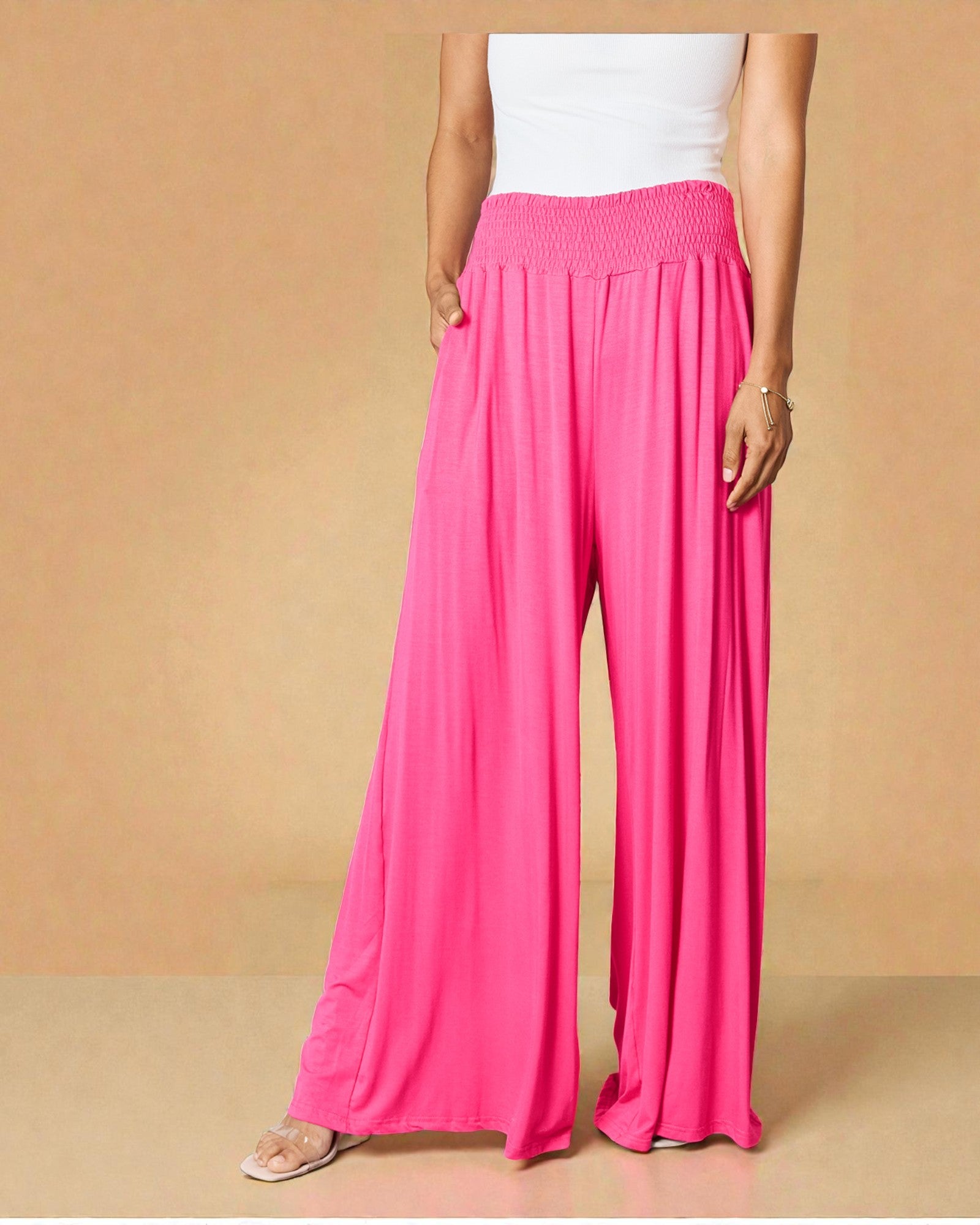 Person wearing bright pink wide-leg pants on a beige background