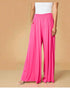 Person wearing bright pink wide-leg pants on a beige background