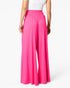 Bright pink wide-leg pants with an elastic waistband, shown on a model from the back against a clean white background.