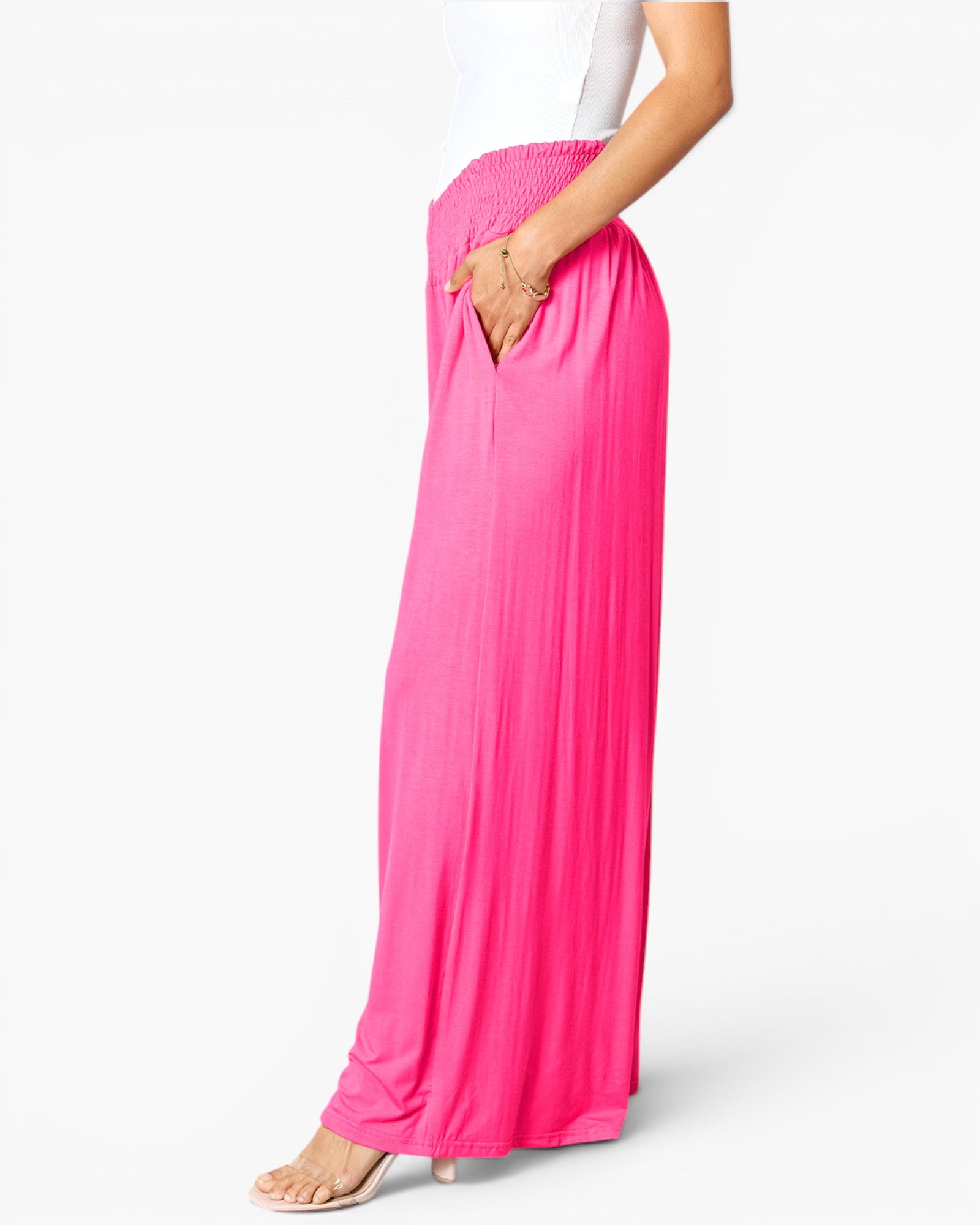 Bright pink wide-leg pleated maxi pants with side pockets, shown on a model from the waist down against a clean white background.