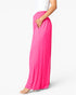 Bright pink wide-leg pleated maxi pants with side pockets, shown on a model from the waist down against a clean white background.