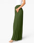 A model wearing olive green wide-leg pleated maxi pants with side pockets, paired with a white top and beige high-heeled sandals, shown from the waist down against a light gray studio background.