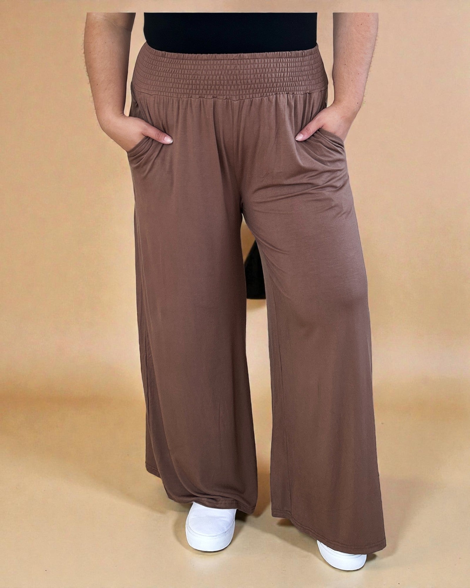 Brown wide-leg pants worn by a person on a beige background