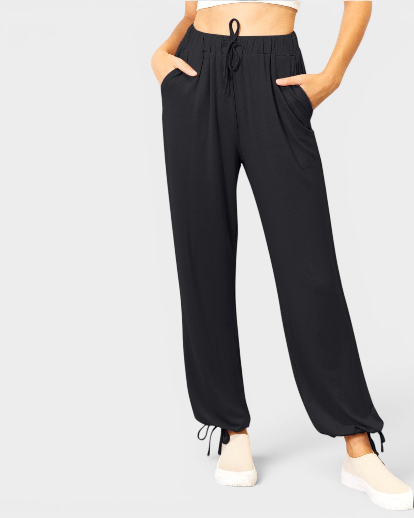 Black drawstring pants worn by a person on a light gray background
