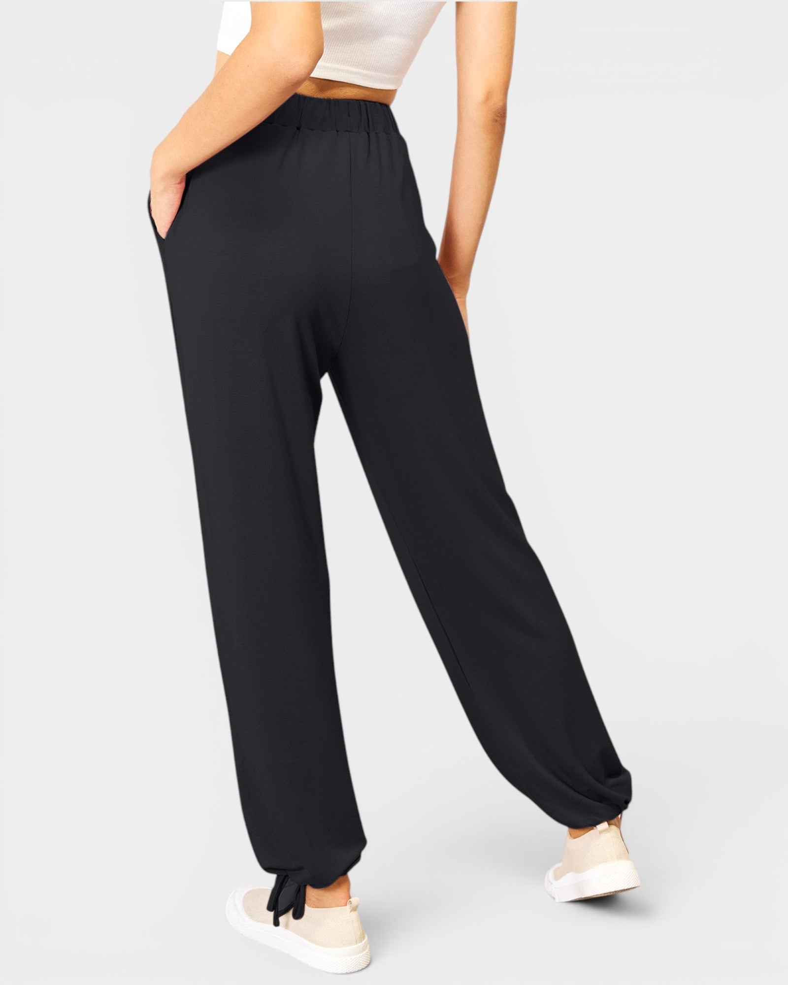 Person wearing black wide-leg pants on a plain background