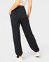 Person wearing black wide-leg pants on a plain background