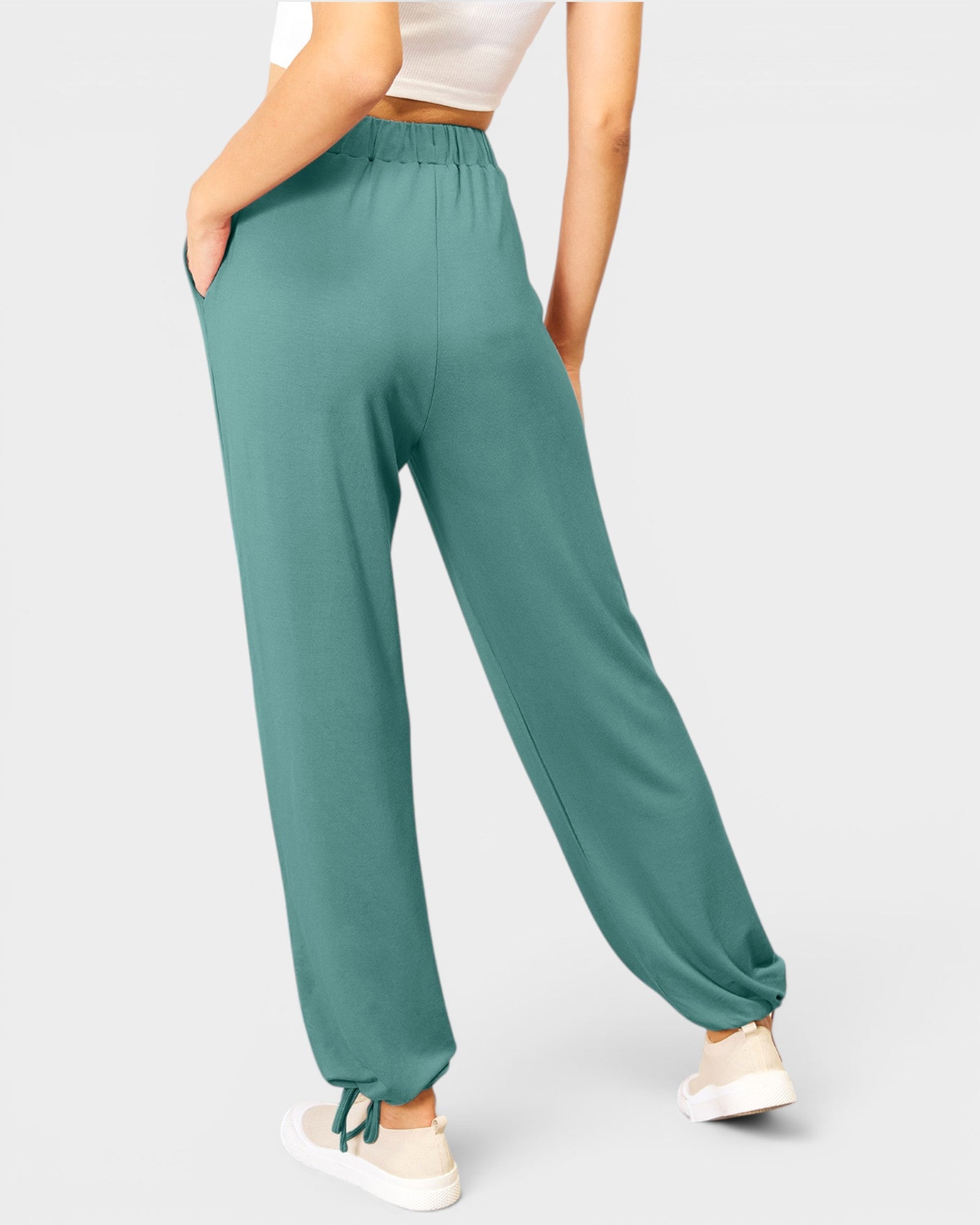 Teal pants worn by a person on a light gray background