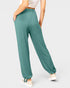 Teal pants worn by a person on a light gray background
