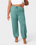 Teal jogger pants worn by a person on a white background