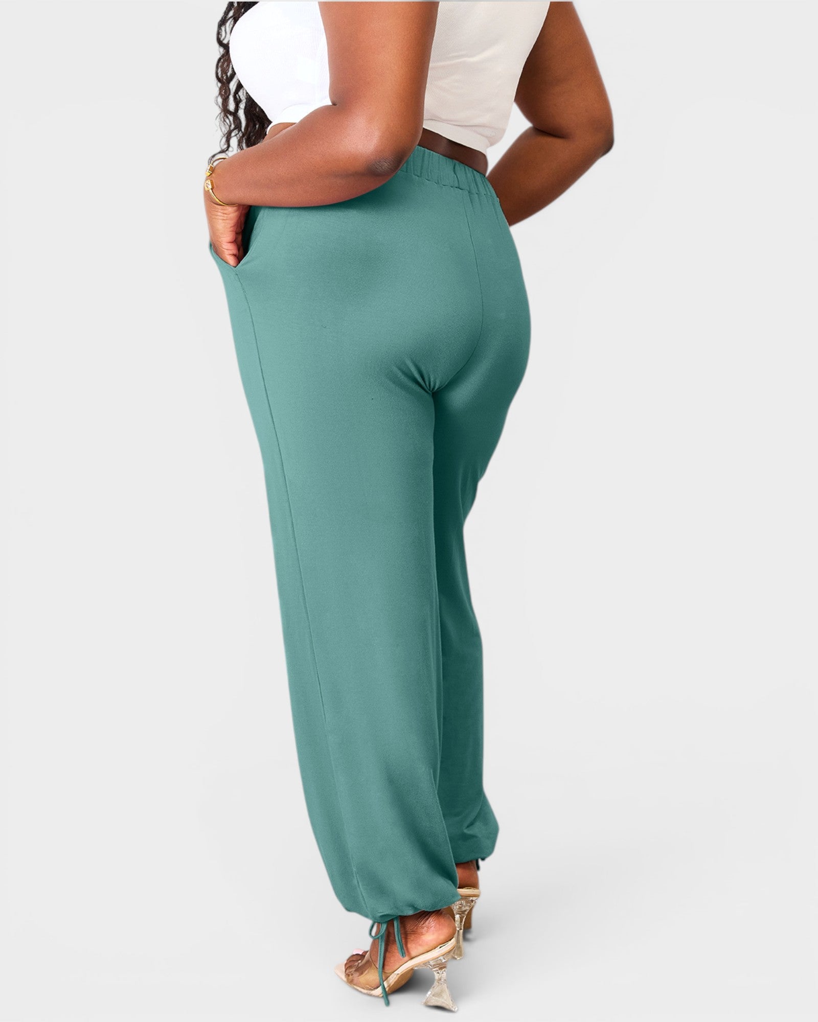 Teal pants worn by a person on a white background