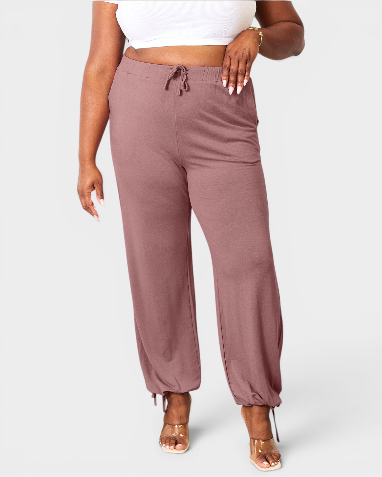 Mauve jogger pants worn by a person on a white background