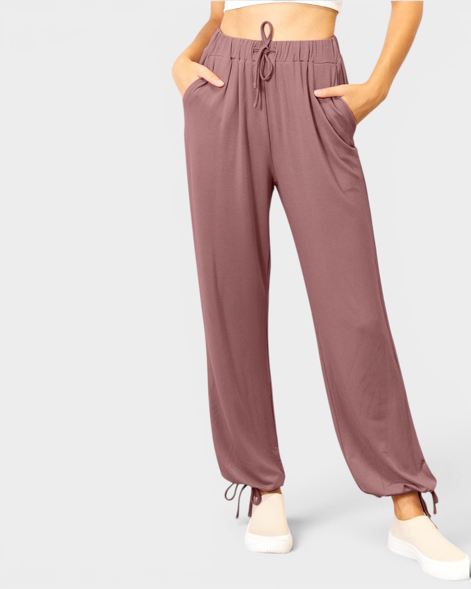 Mauve jogger pants worn by a person on a light gray background