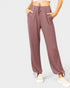 Mauve jogger pants worn by a person on a light gray background