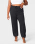 Person wearing black jogger pants on a white background