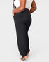 Person wearing black wide-leg pants on a white background