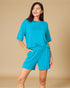 Woman wearing a turquoise outfit on a beige background
