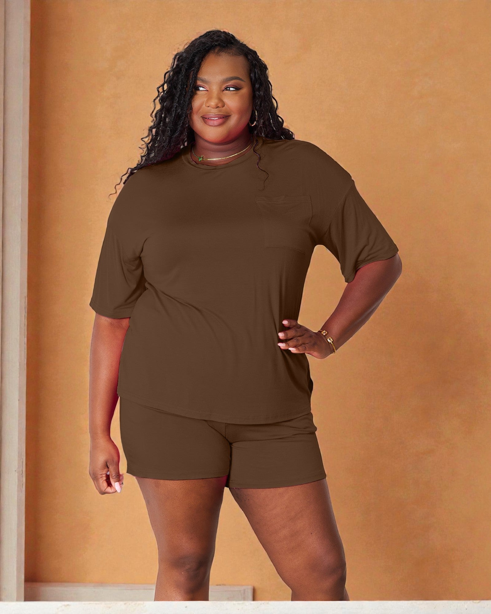 Woman wearing a brown outfit against an orange wall