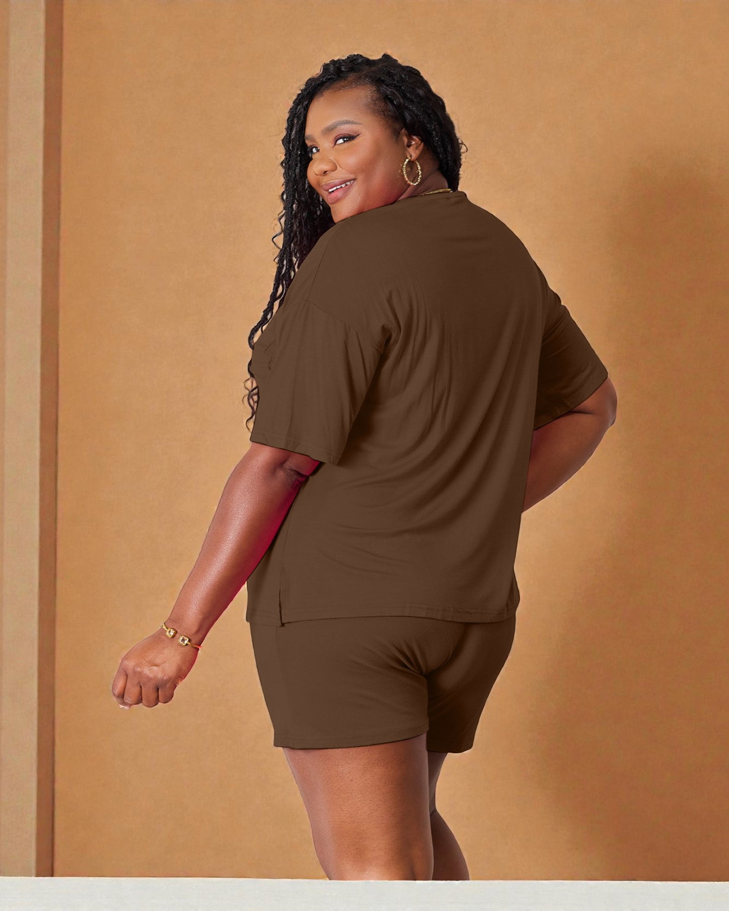 Woman wearing a brown outfit against a beige background