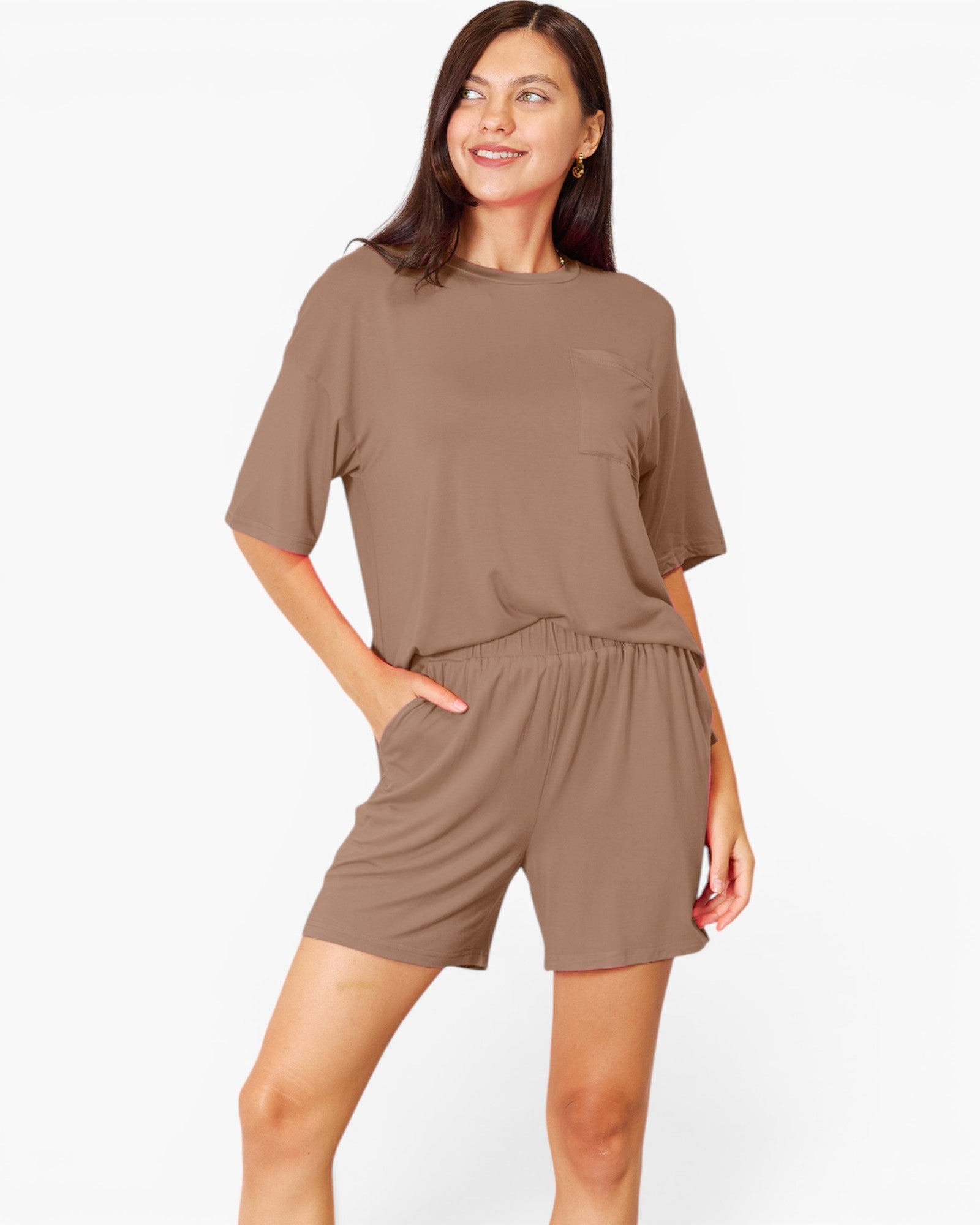 A woman modeling a matching lounge set consisting of a short-sleeve crewneck top and coordinating shorts in a solid taupe-brown color, set against a plain white studio background.
