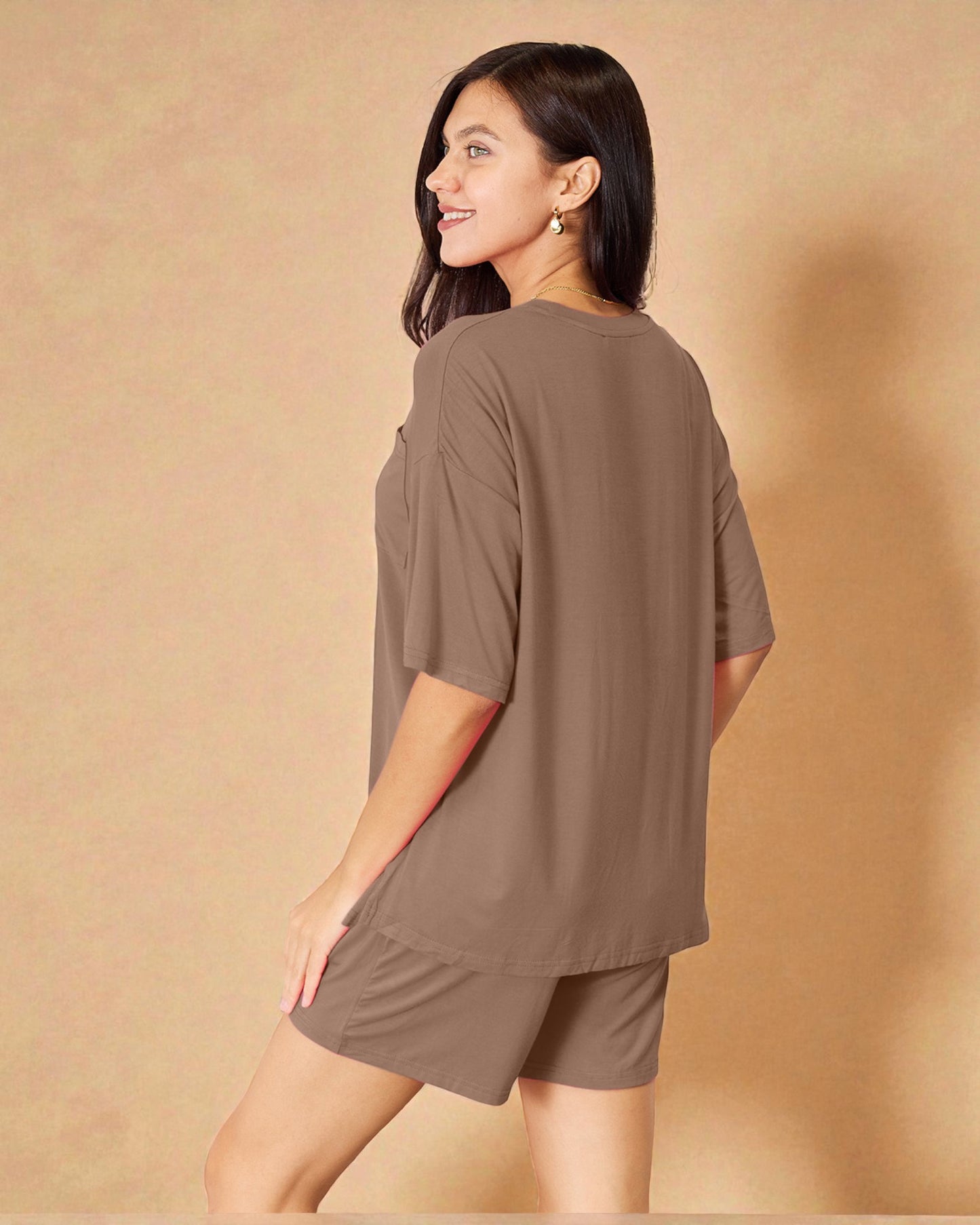 Woman wearing a brown outfit against a beige background