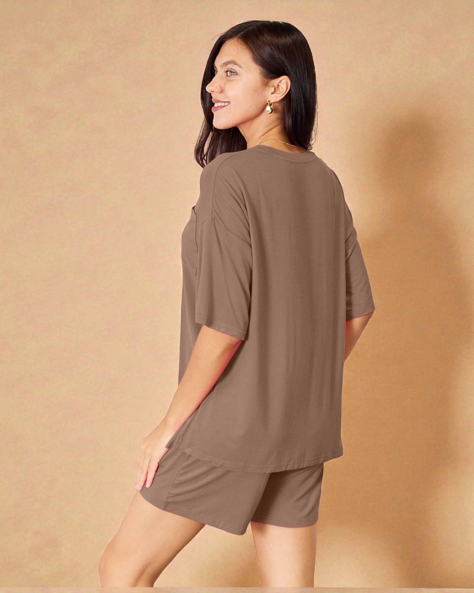 Woman wearing a brown outfit against a beige background