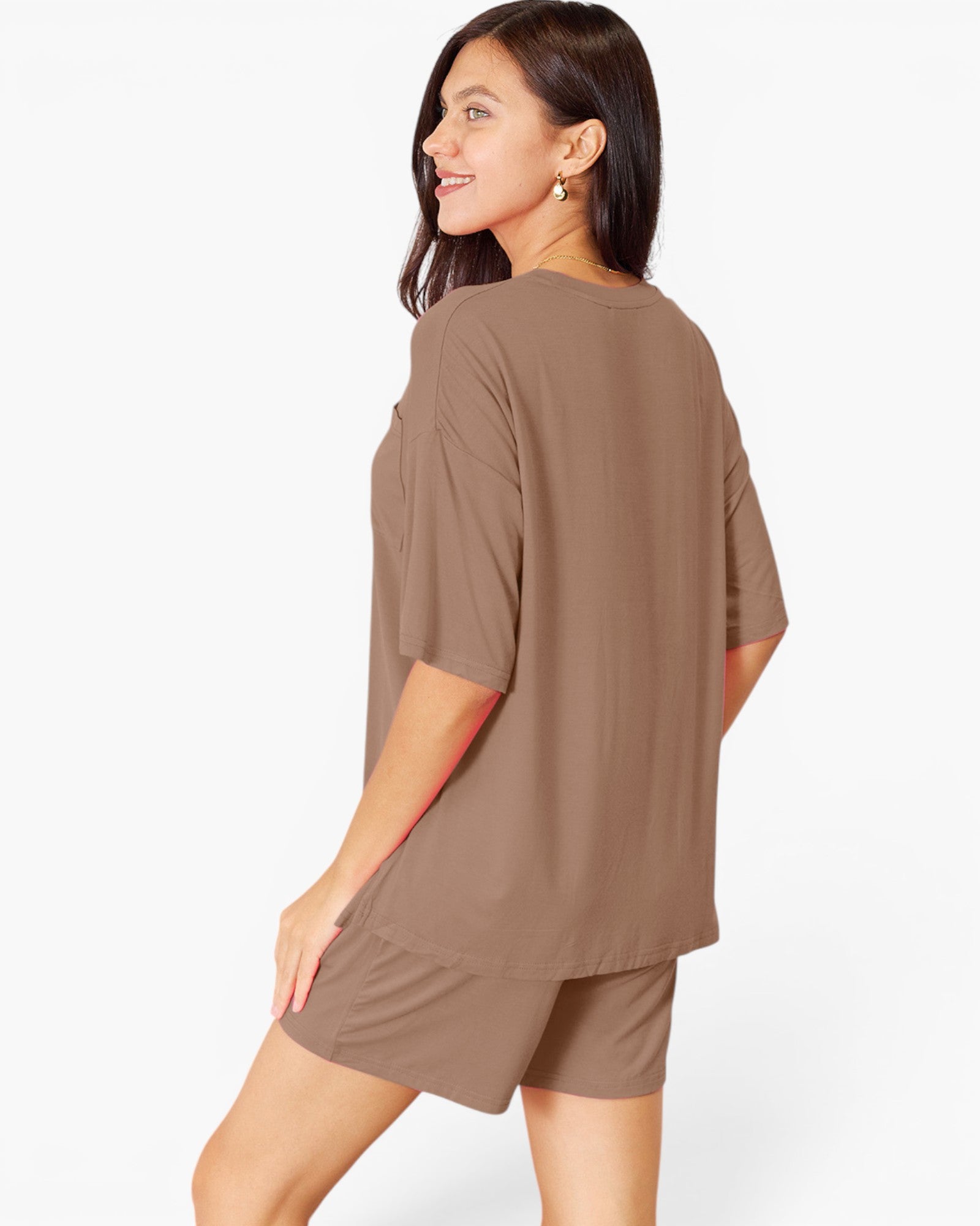 A woman wearing a matching brown lounge set consisting of an oversized short-sleeve top and shorts, shown from a three-quarters back view against a plain white background.