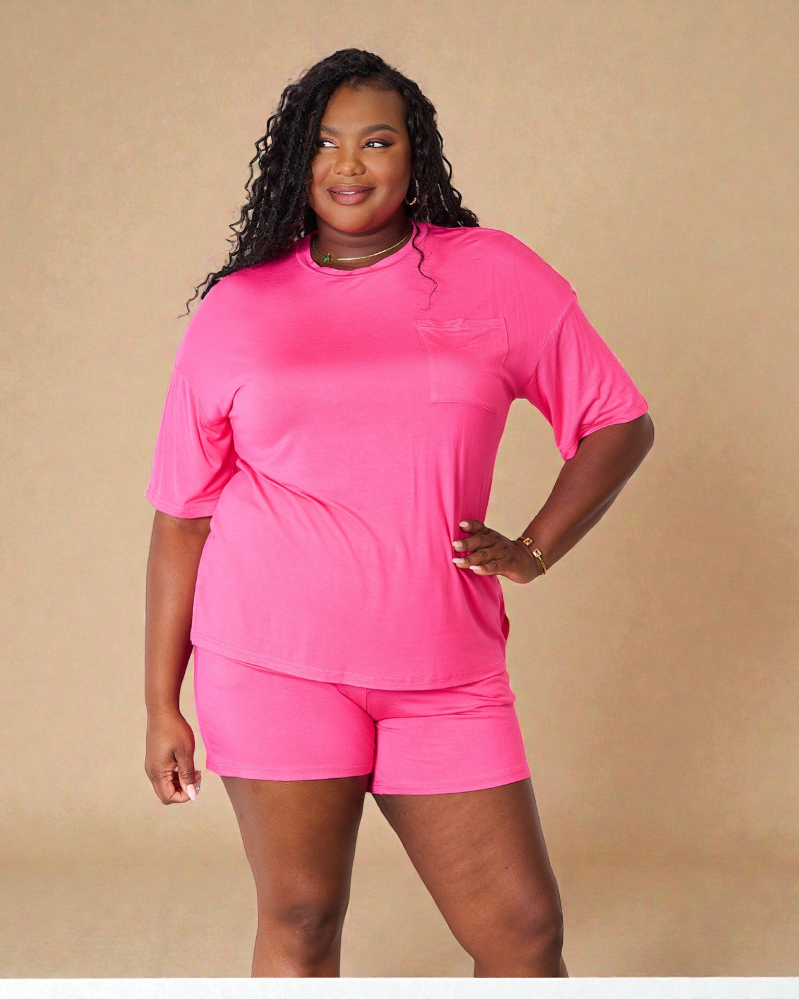 Woman wearing a bright pink outfit on a beige background