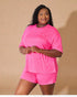 Woman wearing a bright pink outfit against a beige background