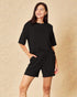 Woman wearing a black outfit on a beige background