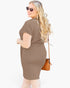 A woman modeling a short-sleeve, bodycon brown dress from the back, wearing round sunglasses and carrying a brown crossbody bag against a plain white background.