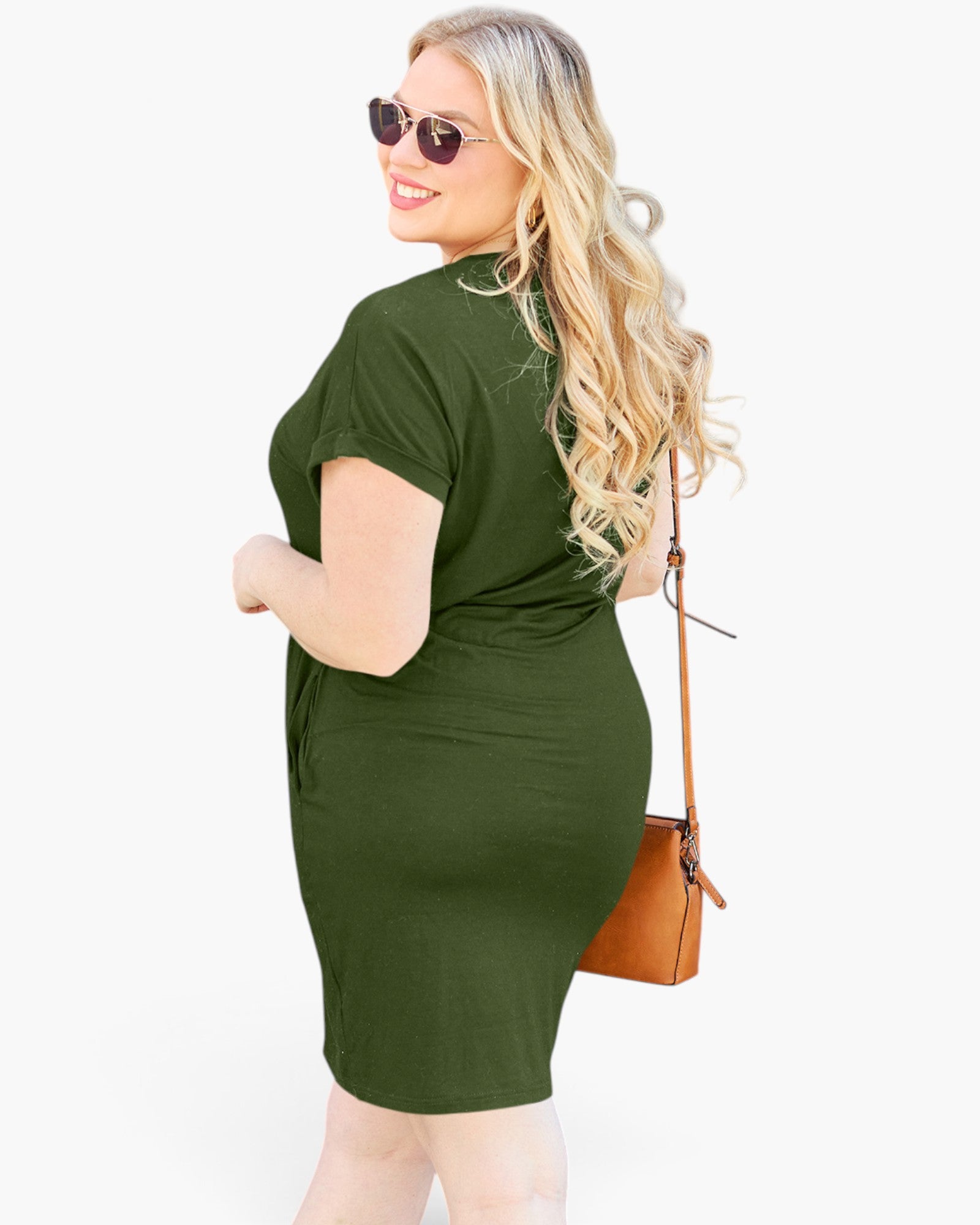 A woman modeling a short-sleeve olive green bodycon dress, shown from a three-quarter back angle. She is wearing round sunglasses and carrying a brown crossbody bag against a solid white background.