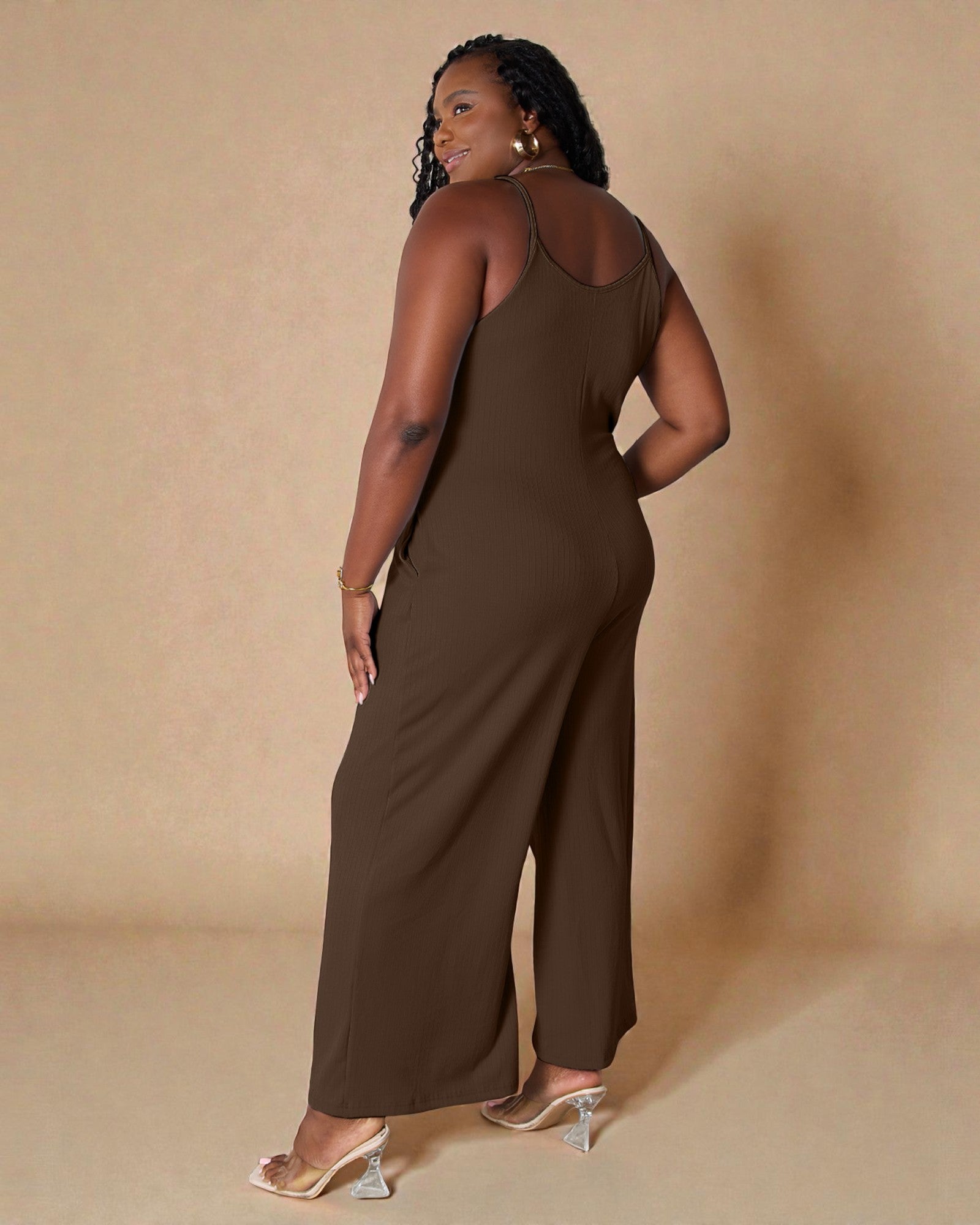 Woman wearing a brown jumpsuit against a beige background