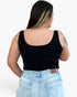A woman shown from the back wearing a black scoop-neck tank top and light blue jeans against a plain white background.