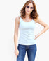 A woman modeling a light blue sleeveless tank top with blue jeans and sunglasses, standing against a plain white background.