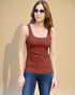 Woman wearing a brown tank top and blue jeans against a beige background