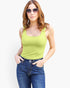A woman modeling a bright lime green scoop-neck tank top paired with blue jeans and sunglasses, set against a plain white background.